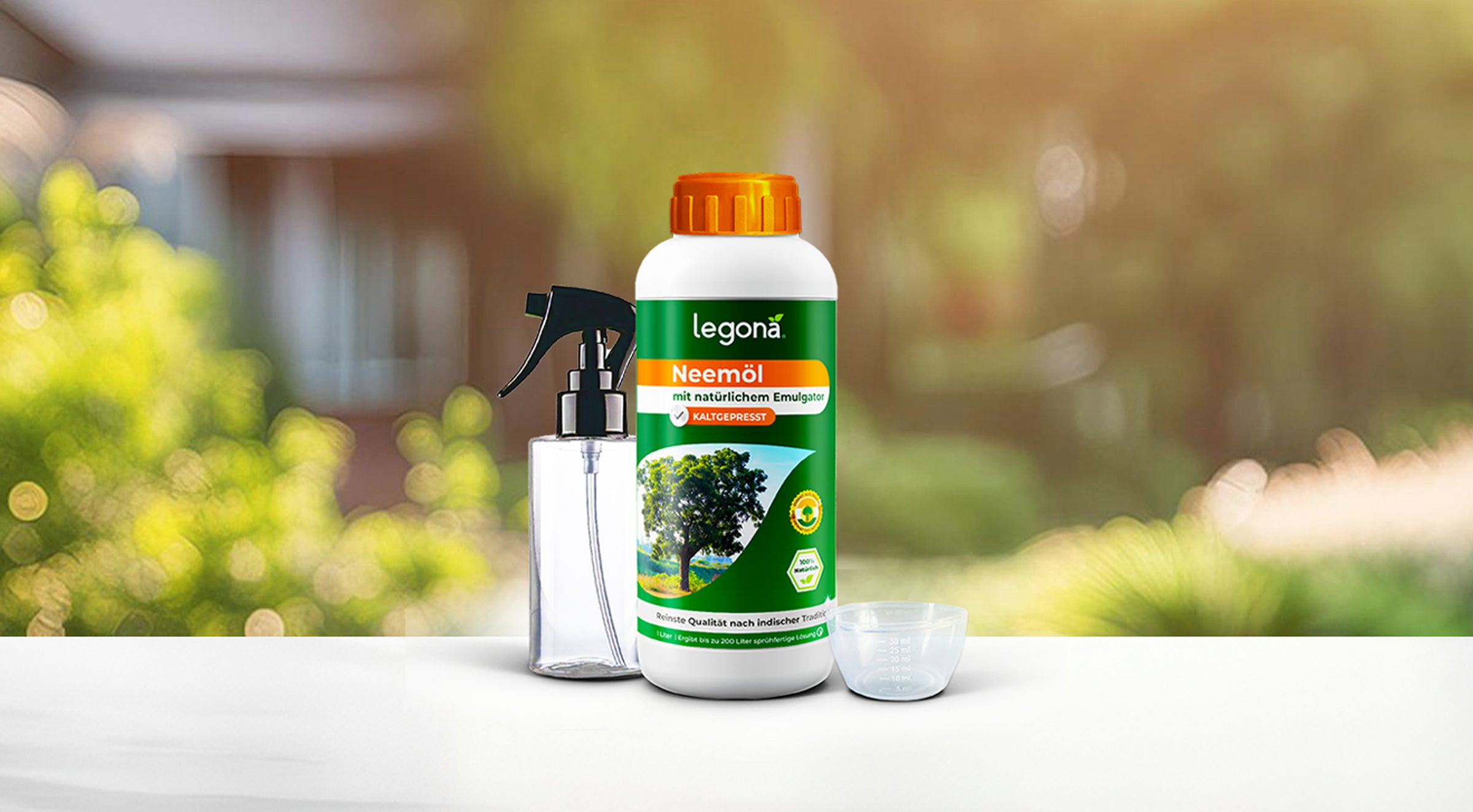 Legona Neemöl in weißer Flasche mit orangefarbenem Verschluss, daneben eine Sprühflasche und ein Messbecher, vor unscharfem Gartenhintergrund